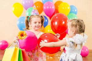 pretty children with colorful balloons and gifts on birthday par