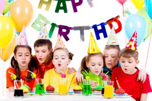 Group of kids blowing candles at the birthday party.